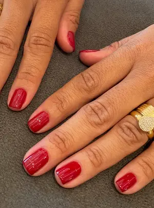Unhas pintadas em vermelho após atendimento de manicure